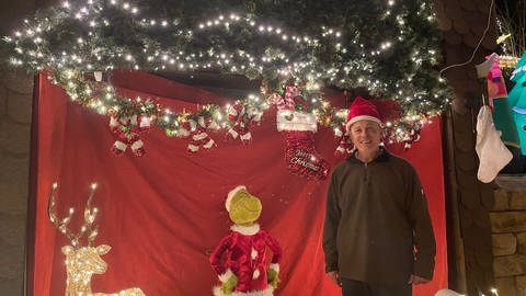 Mann mit Weihnachtsmütze, Dekoration, Lichterkette, Weichnachtsbaum (Foto: SWR)
