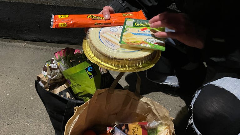 Leon aus Trier zeigt, was er alles an Lebensmittel im Müll von Supermärkten gefunden hat. (Foto: SWR)
