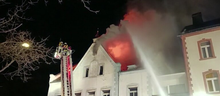 Feuerwehrleute beim Löschen des Brandes in einem Wohn- und Geschäftsgebäude in Neuerburg in der Eifel.  (Foto: SWR)