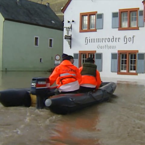 Männer fahren auf einem Boot durch das überschwemmte Kesten (Foto: SWR)