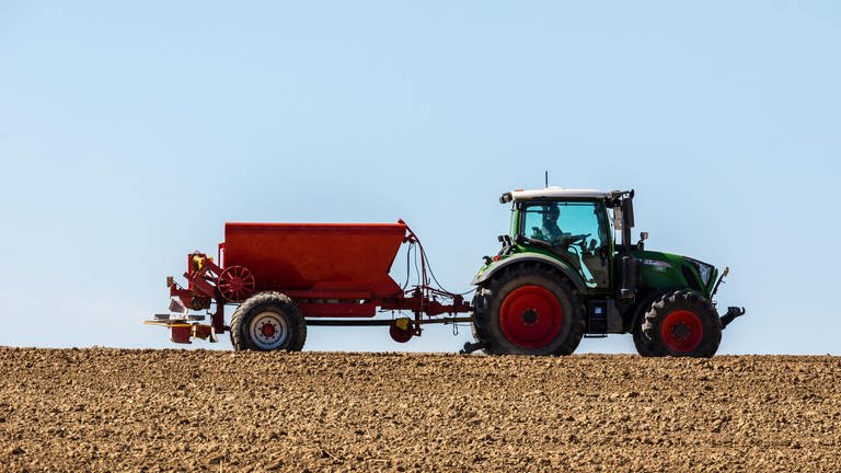 Mit einem Traktor bringt ein Landwirt Dünger aus. Dadurch gelangt schon mal Nitrat ins Grundwasser, so wie in Hetzerath.  (Foto: picture-alliance / Reportdienste, Picture Alliance)