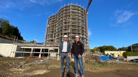 Tyrone Winbush, stellvertretender Vorstandsvorsitzender der Lepper Stiftung (links), und Bauleiter Erich Doll (rechts) sind zuversichtlich, dass das Gebäude der Junior Uni Daun im Herbst 2023 fertig ist. (Foto: SWR, Anna-Carina Blessmann)