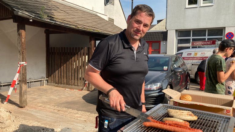 Michael Basten, ein Freund des Elektrikers. Er grillt Bratwürstchen für die Menschen in Trier-Ehrang (Foto: SWR, Eva Lamby-Schmitt)