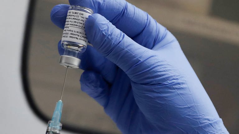 Eine Hand in einem blauen Handschuh zieht den neuen Corona-Impfstoff Novavax auf eine Spritze - Novavax wird ab Rosenmontag auch in den Impfzentren der Region Trier angeboten (Foto: picture-alliance / Reportdienste, dpa Bildfunk, AP / Alastair Grant)