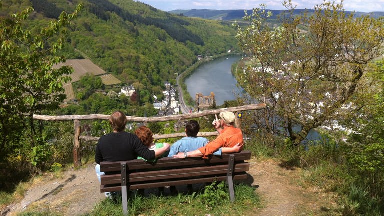 Wanderer sitzen auf einer Bank bei Grevenburg und schauen auf die Mosel.  (Foto: C. Heinen)