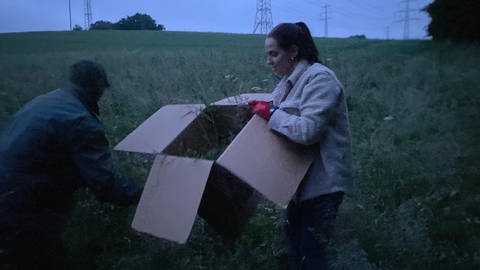 Lara füllt den Karton zusammen mit Michael mit Gras.  (Foto: SWR)