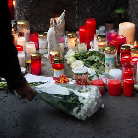 Menschen in Trier legen zum Gedenken an die Amokfahrt Kerzen und Blumen an der Porta Nigra nieder. (Foto: picture-alliance / Reportdienste, Harald Tittel)