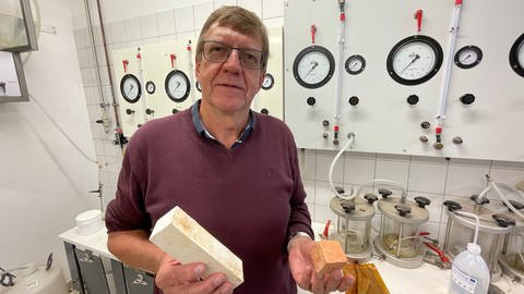 Der Zement der Zukunft ist rot, sagt der Geologe Jean-Frank Wagner von der Universität Trier. In seiner linken Hand hält er das neue Material aus seinem Labor.  (Foto: SWR, Christian Altmayer)