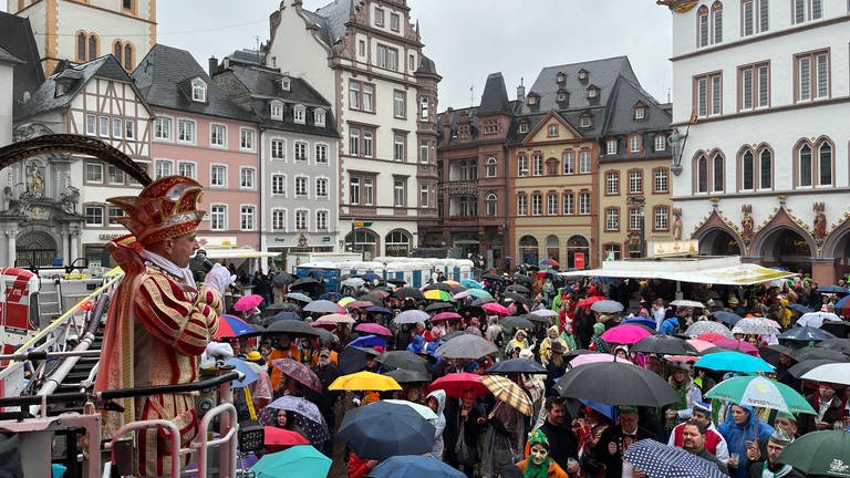 Weiberfastnacht auf dem Hauptmarkt in Trier. Die Narren lassen sich auch durch Regen nicht vom Feiern abhalten. (Foto: SWR)
