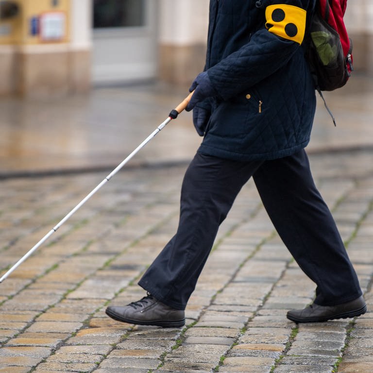 Eine blinde Person geht mit einem Blindenstock (Foto: dpa Bildfunk, Picture Alliance)