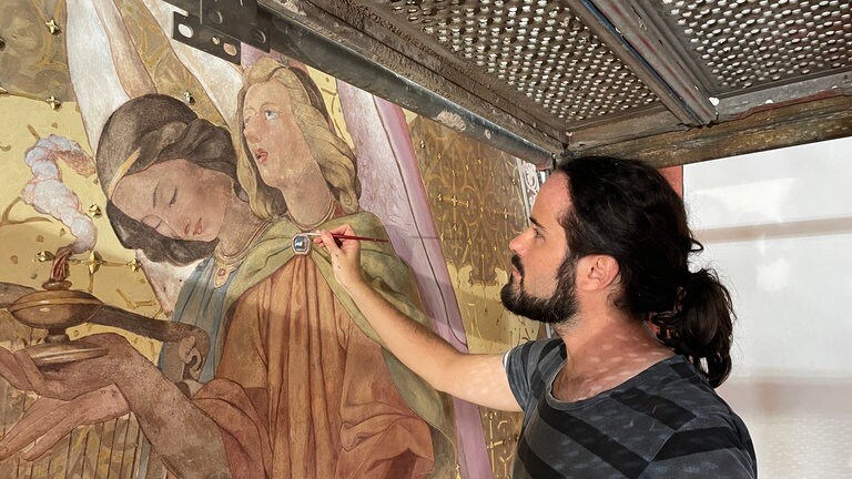 Daniel Brauner restauriert in der Kirche St. Gangolf in Trier das Wandfresko von August Gustav Lasinsky.  (Foto: SWR)