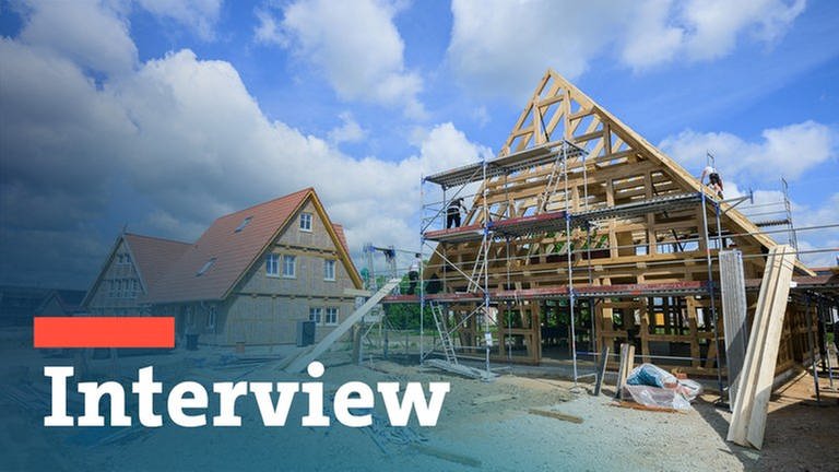 Bildmontage: Baustelle eines Einfamilienhauses aus Holz mit dem Schriftzug Interview (Foto: dpa Bildfunk, Julian Stratenschulte)