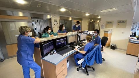 Die Mitarbeiterinnen und Mitarbeiter von Früh- und Spätschicht während ihrer Übergabe auf der Intensivstation 22 am Klinikum Idar-Oberstein. (Foto: SWR)