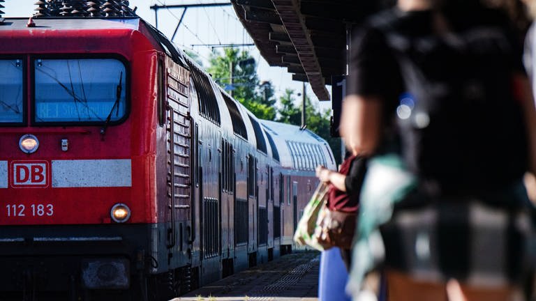 Rote Regionalbahn fährt in Bahnhof ein - In einer Regionalbahn zwischen Trier und Konz wurde ein Bahnmitarbeiter ins Gesicht geschlagen, nachdem er einen Passagier auf die Maskenpflicht hingewiesen hatte