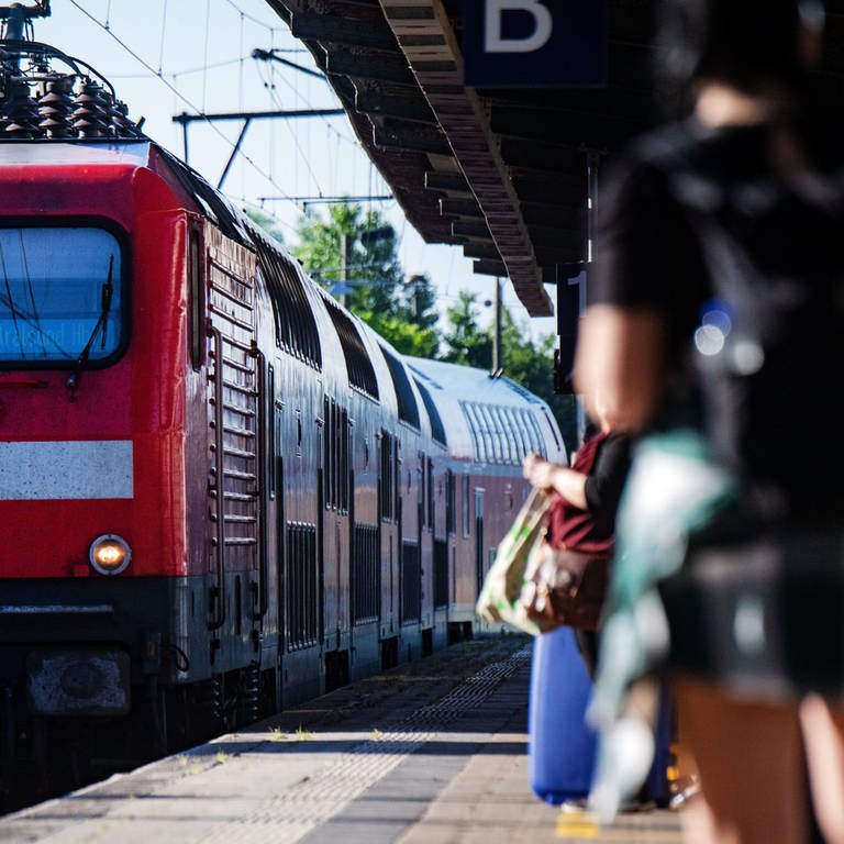 Rote Regionalbahn fährt in Bahnhof ein - In einer Regionalbahn zwischen Trier und Konz wurde ein Bahnmitarbeiter ins Gesicht geschlagen, nachdem er einen Passagier auf die Maskenpflicht hingewiesen hatte (Foto: picture-alliance / Reportdienste, dpa Bildfunk, Stefan Sauer)