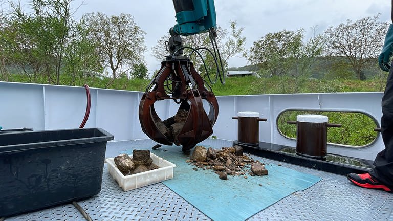 Behutsam wird das Gestein an Bord abgelegt. Die Muscheln am Gestein müssen für die späteren Untersuchungen intakt bleiben. (Foto: SWR, Lara Bousch)