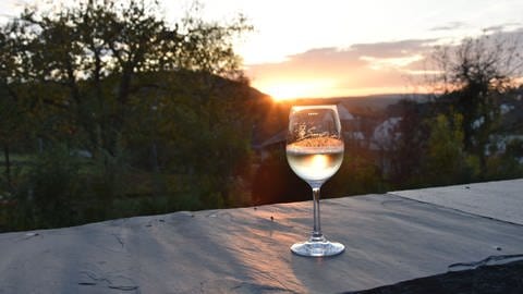 Weinglas mit Moselwein zum Sonnenuntergang mit Panoramablick (Foto: Mosellandtouristik, C. Heinen)