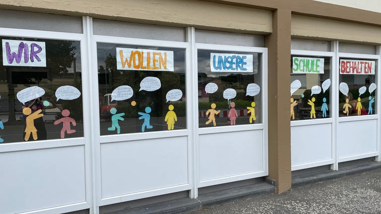 Kinder der Grundschule Bickendorf fühlen sich  wohl an ihrer Dorfschule - so zumindest tun sie es auf Plakaten an den Fenstern kund. (Foto: SWR)