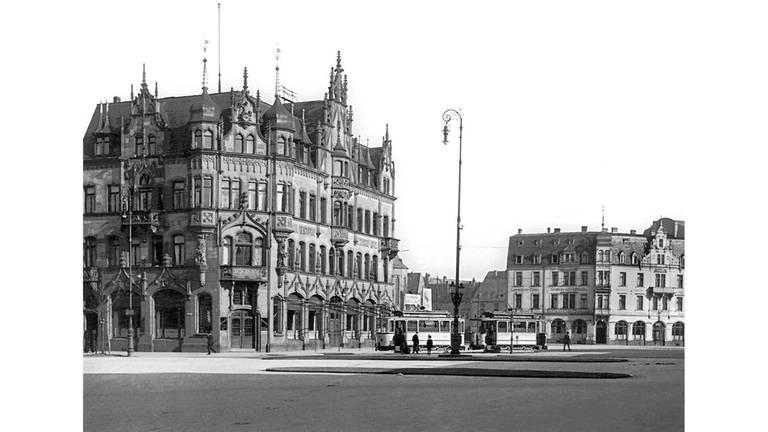 Bahnhofsplatz mit Hotel "Reichshof", um 1900. Der Bahnhofsplatz wird von historistischer Architektur dominiert.