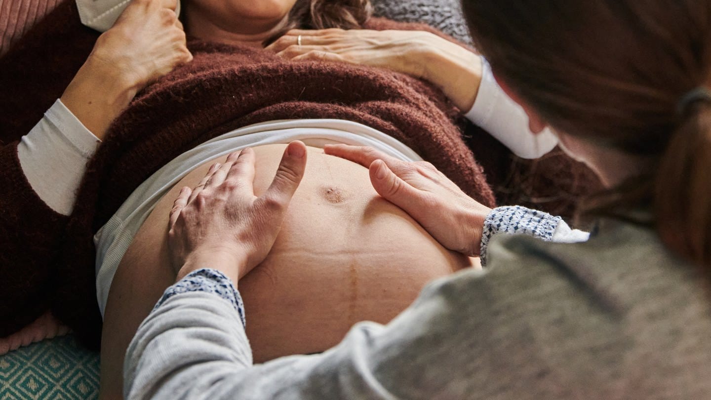 Eine Hebamme tastet den Bauch einer schwangeren Frau ab. (Foto: dpa Bildfunk, picture alliance/dpa | Annette Riedl)