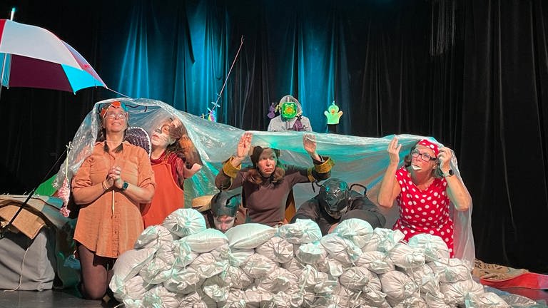 Schutz vor Regen. Das inklusive Com.guck Theater Trier in einer Szene ihres Stücks "Land unter" (Foto: SWR, Nicole Mertes )
