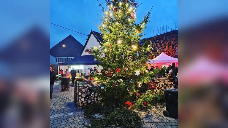 Beim Weihnachtsmarkt in Birresborn versammeln sich alle um den zentralen Weihnachtsbaum.
