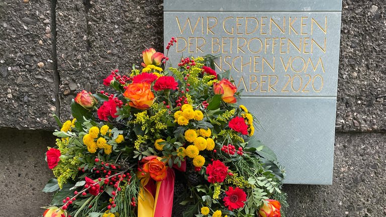 Ein frischer Kranz liegt am dritten Jahrestag der Amokfahrt vor der Gedenkplakette an der Porta Nigra in Trier.