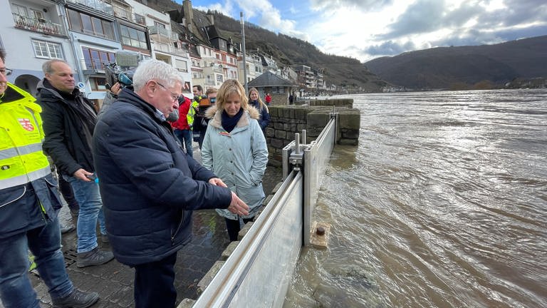 Zells Stadtbürgermeister Hans-Peter Döpgen (FWG) zeigt Umweltministerin Kartin Eder (Die Grünen), wie die Hochwasserlage vor Ort ist.