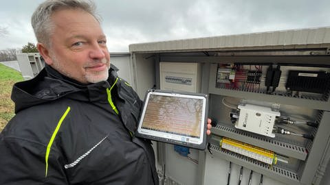 Wenn Techniker Ulf Wollstädter sein Tablet an die Messstation anschließt, kann er jede kleinste Erschütterung auf dem Bildschirm sehen.  (Foto: SWR, Christian Altmayer)