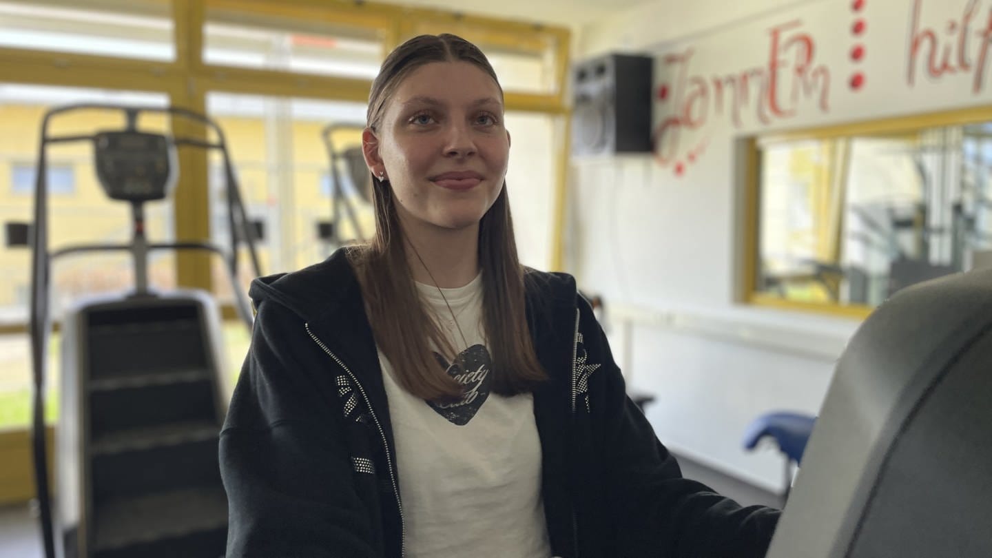 Die 16-jährige Miriam sitzt auf einem Trimmrad im Sportraum der Edelsteinklinik, an dem sie regelmäßig trainiert. (Foto: SWR)