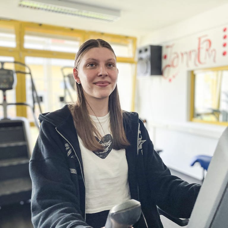 Die 16-jährige Miriam sitzt auf einem Trimmrad im Sportraum der Edelsteinklinik, an dem sie regelmäßig trainiert.