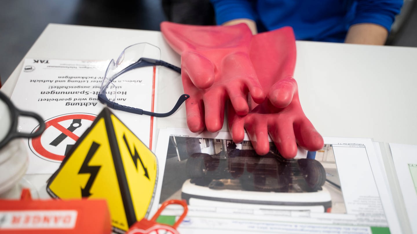 Arbeitsmaterialien - darunter Handschuhe - liegen auf einem Tisch. (Foto: dpa Bildfunk, picture alliance/dpa | Frank Rumpenhorst)