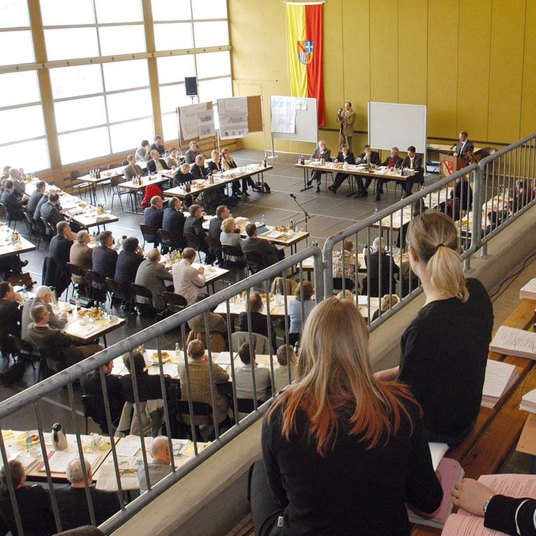 Zuhörer verfolgen eine Sitzung der Kreistagssitzung des Landkreises Karlsruhe. (Foto: IMAGO, Gustavo Alabiso)
