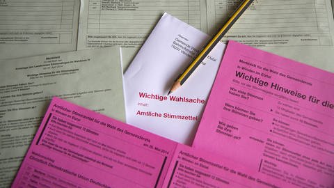Stimmzettel für die Kommunalwahl liegen ausgebreitet auf einem Tisch. (Foto: imago images, Eibner)