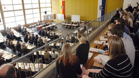 Zuhörer verfolgen eine Sitzung der Kreistagssitzung des Landkreises Karlsruhe. (Foto: IMAGO, Gustavo Alabiso)