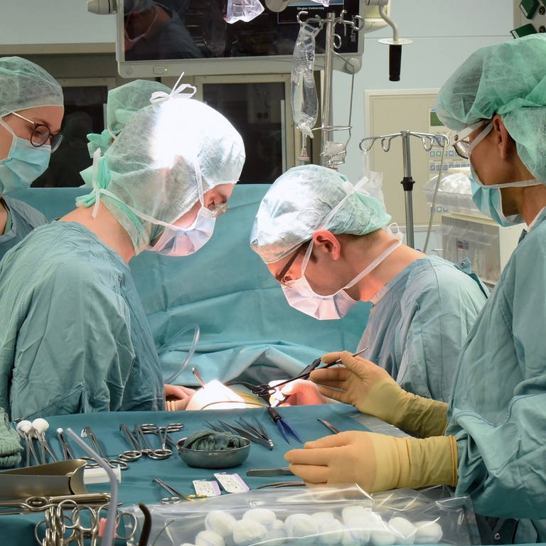 Zwei Ärzte (Mitte) arbeiten im Transplantationszentrum am Universitätsklinikum bei einer Operation (Foto: picture-alliance / Reportdienste, picture alliance/dpa/dpa-Zentralbild | Waltraud Grubitzsch)