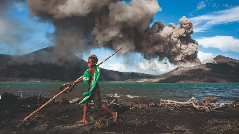 Tavurvur, Papua-Neuguinea – Munganau kennt nichts anderes als das Leben mit dem Tavurvur. Seitdem er auf der Welt ist, spuckt der Vulkan fast täglich Asche, Lavabomben und lässt den Himmel nachts leuchten. (Foto: Pressestelle, © Ulla Lohmann/Knesebeck Verlag)