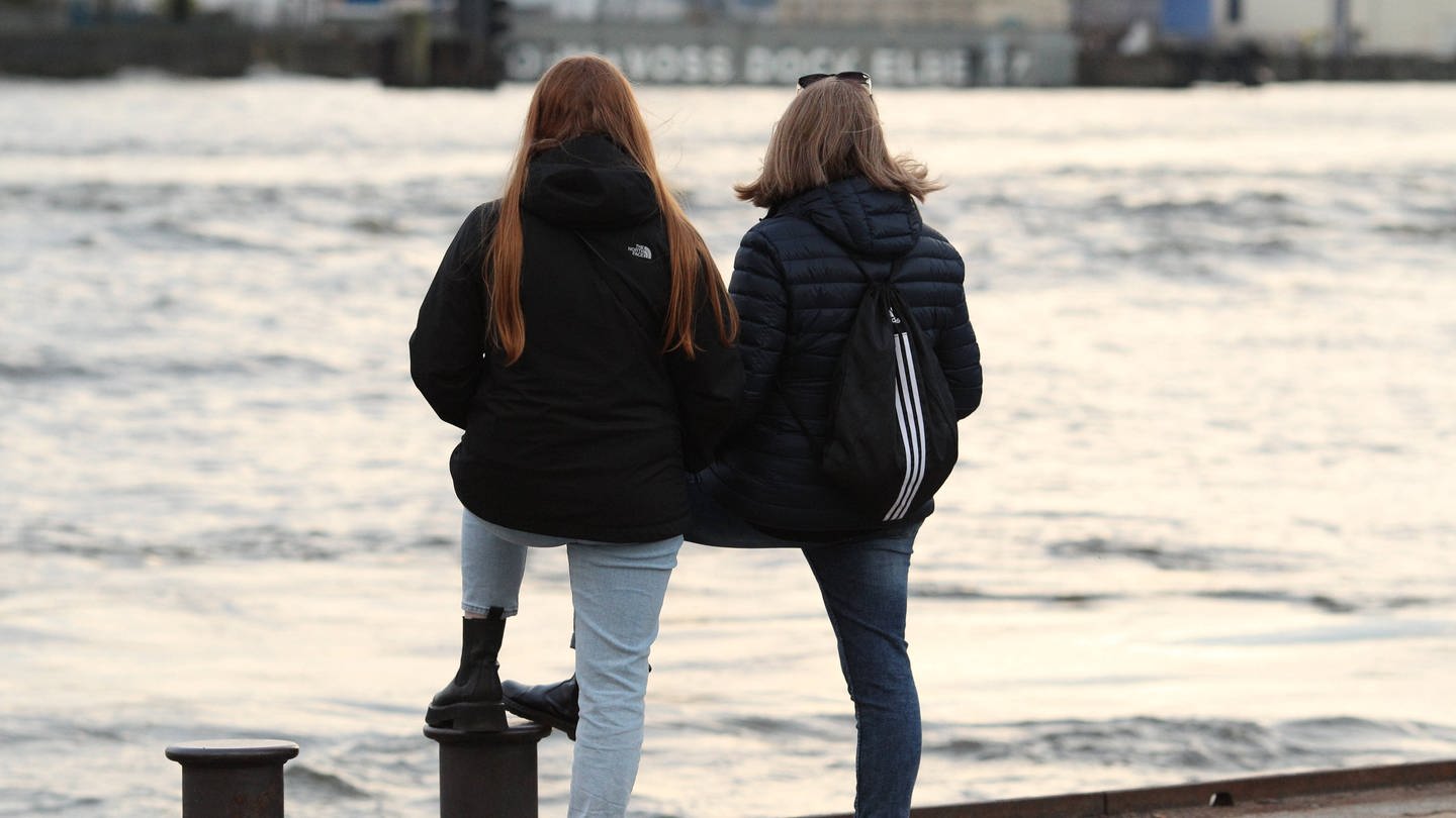 Freundinnen stehen an einer Hafenkante und schauen aufs Wasser (Foto: IMAGO, IMAGO / Hanno Bode)