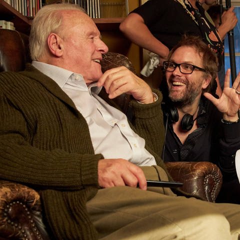 Autor und Regisseur Florian Zeller sitzt bei Dreharbeiten für "The Father" mit Schauspieler Anthony Hopkins zusammen.