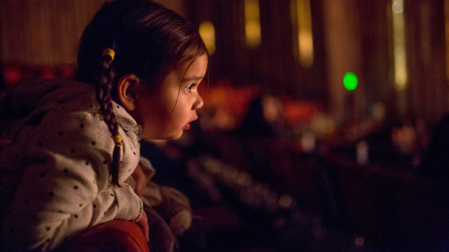 Ein Mädchen lehnt sich im Theatersaal neugierig über die Lehne (Foto: picture-alliance / Reportdienste,  Bildagentur-online/Blend Images | Blend Images/Adam Hester)