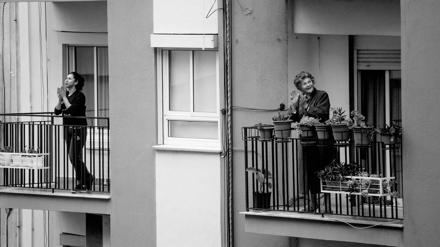 Zwei Frauen auf zwei Balkonen (Foto: Unsplash / Manuel Peris Tirado)