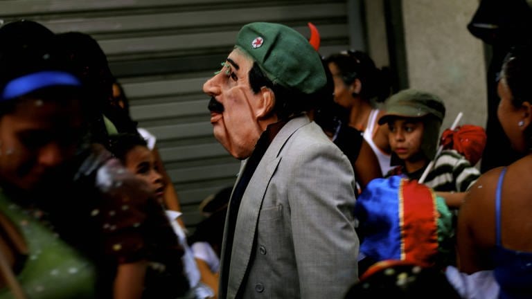 Eine Person mit Hugo-Chávez-Maske bei einem Karnevalsumzug  (Foto: IMAGO,  Aurora Photos)