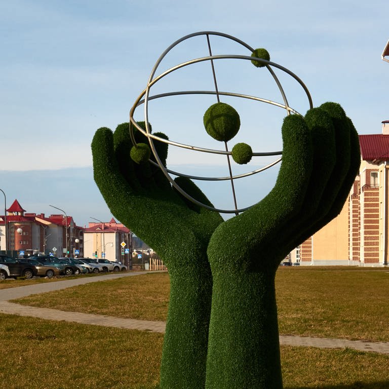 Riesige Hände wiegen ein Atom, die zwei Meter hohe Skulptur am Ortseingang von Astravet.