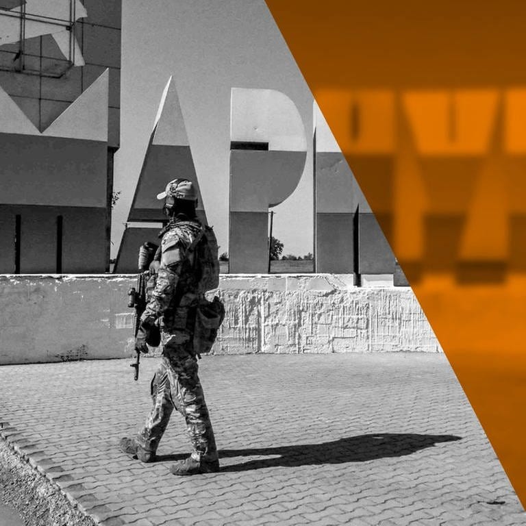 Ein Russicher Soldat patrolliert beim einem Willkommensschild vor dem Eingang zu Mariupol