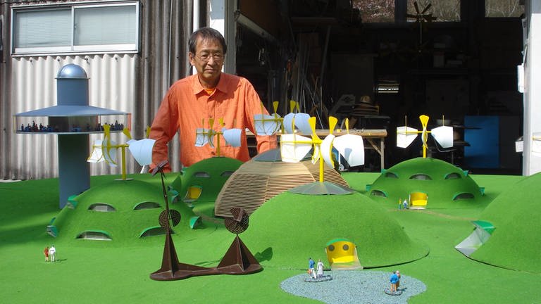 Susumu Shingu und ein Modell seines Dorfprojekts "Breathing Earth" (Foto: Pressestelle, Malte Jaspersen)
