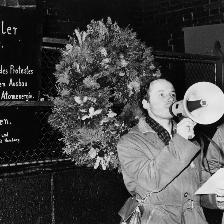 Pastor Ulfried Kleinert hält vor der Gedenktafel eine Rede. Am 22.11.1977 wurde vor der Petri-Kirche in Hamburg an der Stelle, an der sich der Tübinger Lehrer Hartmut Gründler aus Protest gegen die Kernenergie verbrannt hatte, eine Gedenktafel enthüllt.