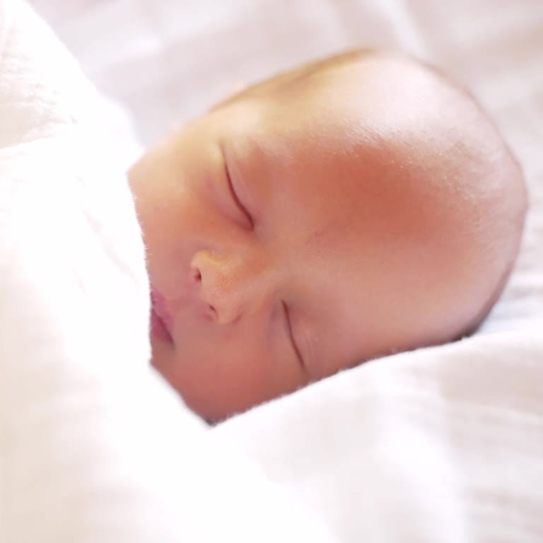 Neugeborener schlafender Junge mit Schnuller