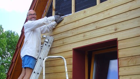 Schriftsteller Michael Sollorz beim renovieren der Hausfassade