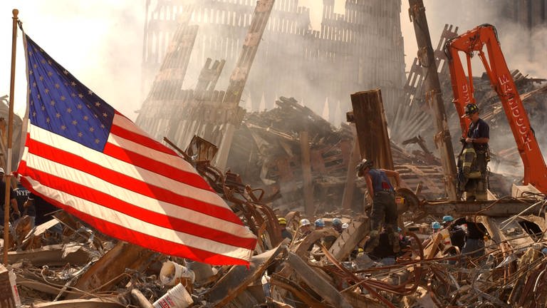 Eine US-amerikanische Flagge weht auf dem Trümmerfeld nach dem Einsturz beider Türme des World Trade Centers.
