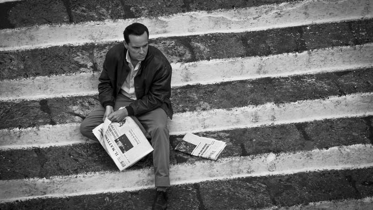 Andrew Scott als Tom Ripley. Er sitzt auf einer Treppe, mit einer Zeitung in der Hand. (Foto: IMAGO, IMAGO / Landmark Media)